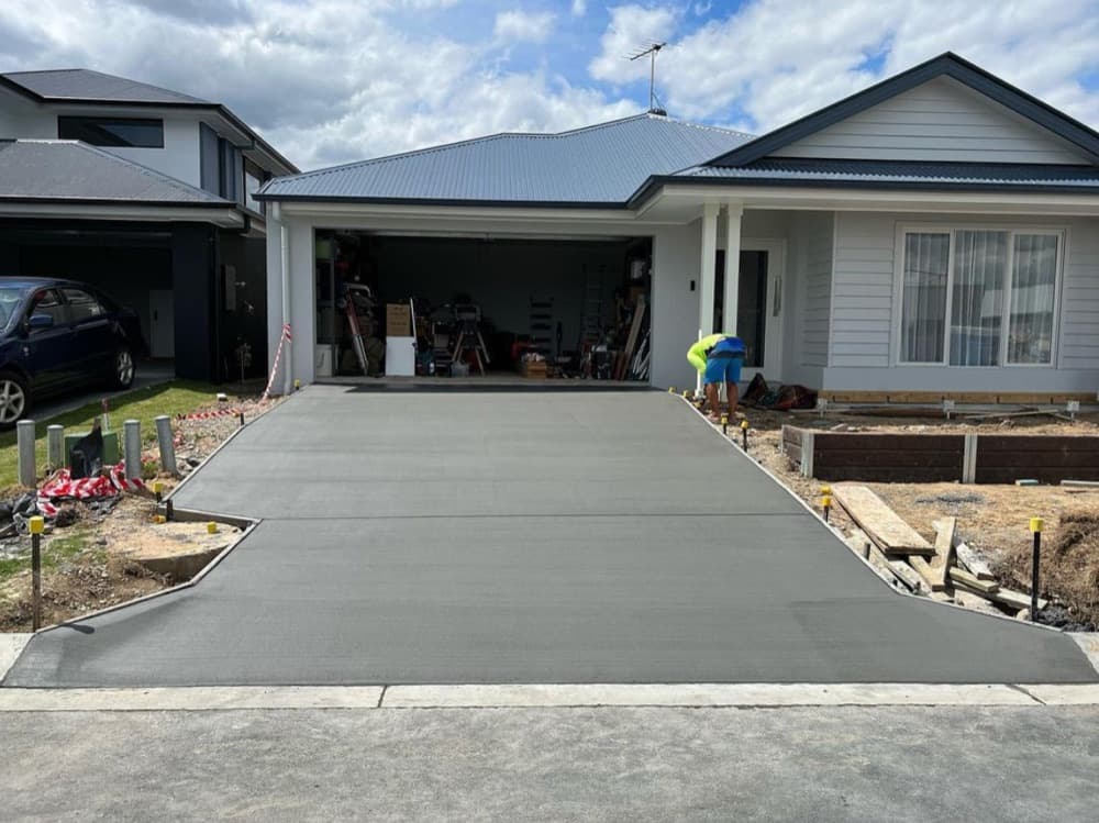 New concrete driveway leading up to a carport